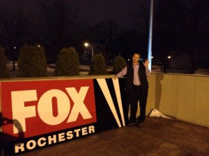 WROC's Scott Hetsko poses with the WUHF sign after it was removed from WROC's building in December